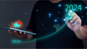 Homem segura tablet com envelope email 2020, mostrando uma linha ascendente com carrinho de compras, começando em 2023 a mostrar o 2024 de sucesso